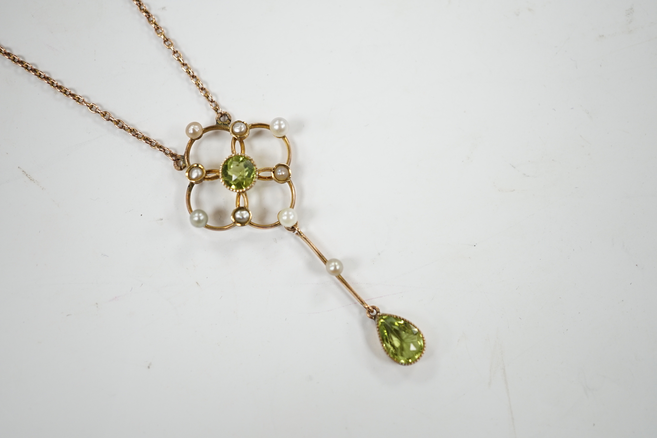 An Edwardian 9ct, peridot and seed pearl set drop pendant necklace, 49cm, gross weight 3.5 grams.